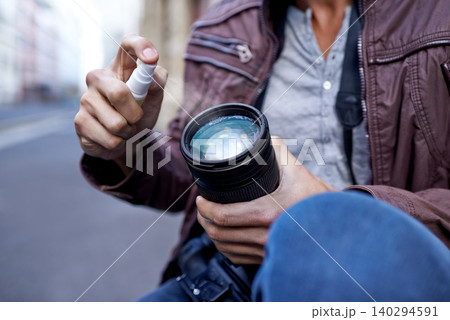 Hands, man and photographer with spray for camera lens to clean for work, create portfolio in streets of Berlin. Closeup, artist and picture in public space for career in media and creativity. 140294591