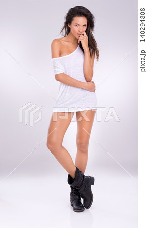 Female model person, studio and portrait for fashion, boots and tshirt on isolated white background. Confidence, edgy clothing style and fit figure in Australia, smooth legs and radiant on backdrop 140294808