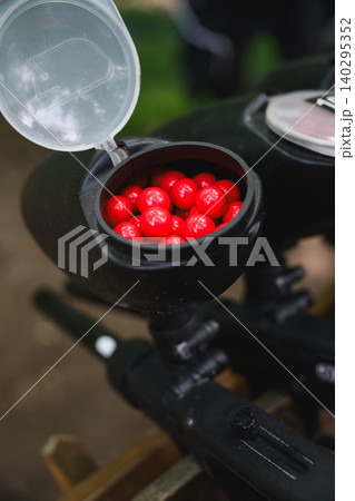 Paintball Marker Hopper Loaded With Red Paintballs 140295352