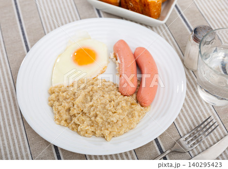 Continental breakfast for one person - portion of oatmeal, fried egg and sausage Continental breakfast for one person - portion of oatmeal, fried egg and sausage 140295423