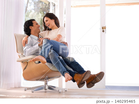 Laughing, conversation and couple on chair in living room at home with comfortable romance and care. Happy, marriage and young man and woman sitting, talking and bonding together in lounge at house. Laughing, conversation and couple on chair in living room at home with comfortable romance and care. Happy, marriage and young man and woman sitting, talking and bonding together in lounge at house. 140295465