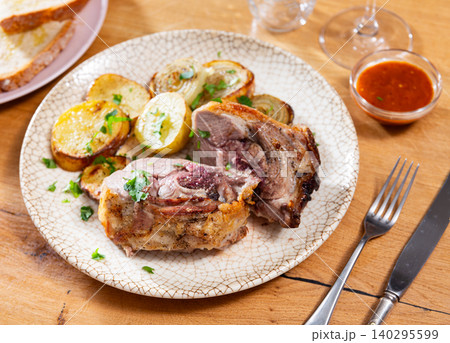 Leg of lamb served with potatoes and onions Leg of lamb served with potatoes and onions 140295599