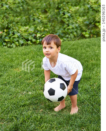 Portrait, boy or catch with soccer ball in park for fun, health or childhood development in Portugal. Happy, confident and male child with football for game or exercise in backyard or garden 140296163