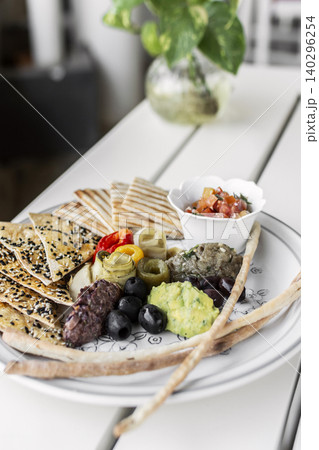 mixed vegan vegetarian mediterranean tapas snack platter on white table in outdoor cafe 140296254