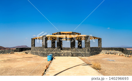 Stone and wood Wabah Crater Main View observation deck in Hafir Kishb, Saudi Arabia, under a clear blue sky 140296693