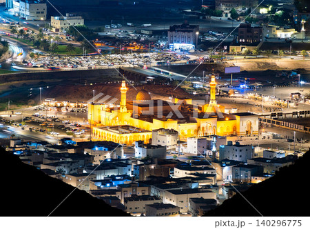 Aerial night view of the illuminated Masjid Sayed Al Shouhada mosque and surrounding city traffic in Madinah, Saudi Arabia. Aerial night view of the illuminated Masjid Sayed Al Shouhada mosque and surrounding city traffic in Madinah, Saudi Arabia. 140296775