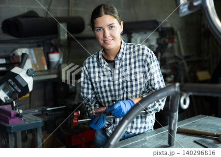 Portrait of young female worker at metallurgical plant with caliper in her hands Portrait of young female worker at metallurgical plant with caliper in her hands 140296816