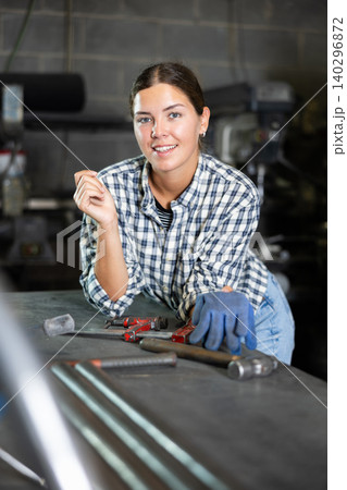 Young woman posing in metallurgical workshop Young woman posing in metallurgical workshop 140296872