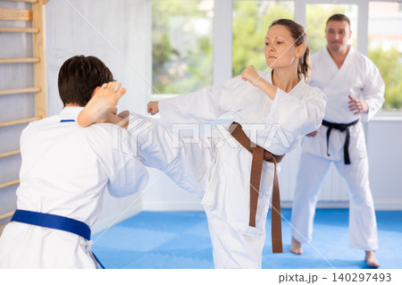 Man and woman train to perform basic defensive attacking actions during mortal techniques classes Man and woman train to perform basic defensive attacking actions during mortal techniques classes 140297493