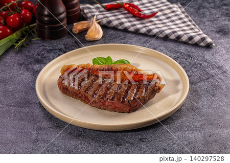 Grilled Picanha Steak with Golden Fat Cap and Fresh Basil on Beige Plate 140297528