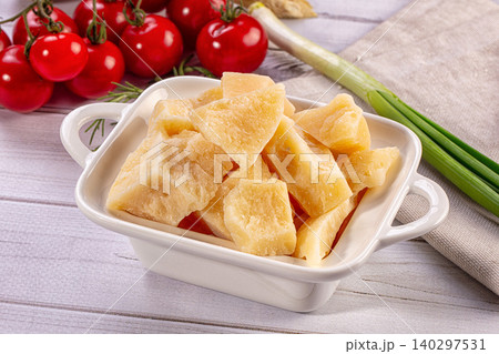 Parmesan cheese chunks in white bowl with cherry tomatoes, green onions, rosemary on wood background 140297531