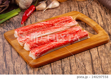 Fresh surimi crab sticks on rustic wooden cutting board with garlic chili Fresh surimi crab sticks on rustic wooden cutting board with garlic chili 140297558