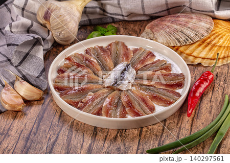 Marinated Anchovy Fillets on White Plate with Garlic, Chili, Green Onion, Basil, Scallop Shells, Rustic Wood Background Marinated Anchovy Fillets on White Plate with Garlic, Chili, Green Onion, Basil, Scallop Shells, Rustic Wood Background 140297561