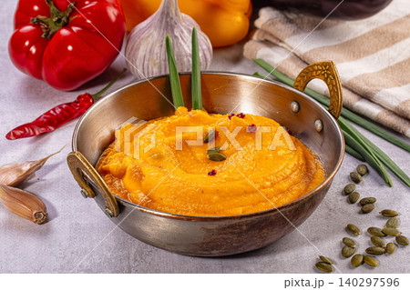 Creamy vegetable puree with pumpkin seeds in metal bowl surrounded by fresh ingredients Creamy vegetable puree with pumpkin seeds in metal bowl surrounded by fresh ingredients 140297596