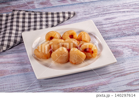 Peeled lychee fruit in syrup on white plate over rustic wooden table Peeled lychee fruit in syrup on white plate over rustic wooden table 140297614