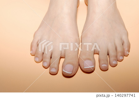 Well groomed female feet with french pedicure Well groomed female feet with french pedicure 140297741