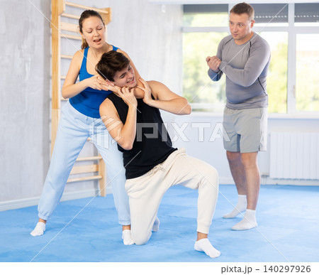 Woman makes a choke hold in self defense trainin Woman makes a choke hold in self defense trainin 140297926