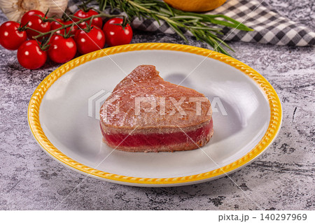 Gourmet seared rare tuna steak on plate with fresh cherry tomatoes and rosemary 140297969