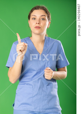 Serious young female medic in blue uniform warning about prohibitions 140298407