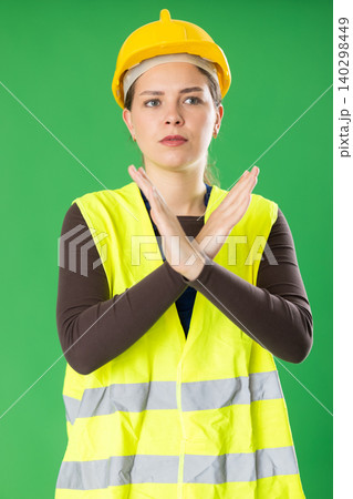 Young woman in reflective vest and hard hat explaining safety instructions 140298449
