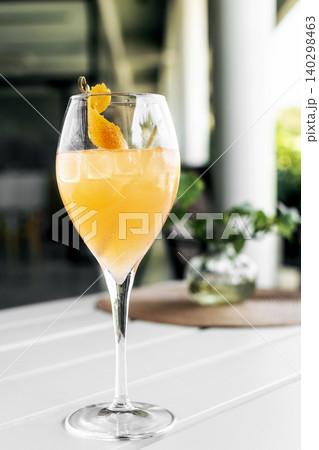 screwdriver vodka and orange cocktail in wine glass on white table in outdoor garden restaurant screwdriver vodka and orange cocktail in wine glass on white table in outdoor garden restaurant 140298463