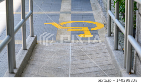 Yellow painted handicapped sign traffic symbol on the floor in front of ramp way for support wheelchair Yellow painted handicapped sign traffic symbol on the floor in front of ramp way for support wheelchair 140298838