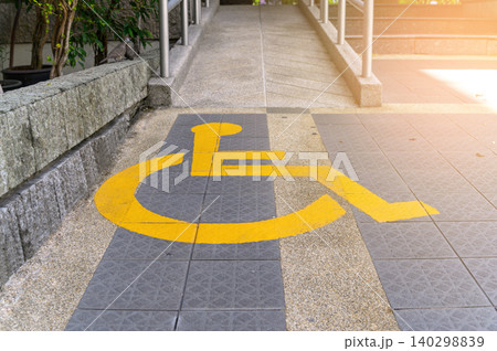 Yellow painted handicapped sign traffic symbol on the floor in front of ramp way for support wheelchair Yellow painted handicapped sign traffic symbol on the floor in front of ramp way for support wheelchair 140298839