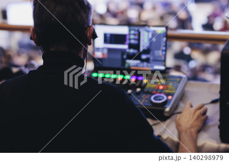 Lighting technician operator working on mixing console, workplace during live event, stage concert show broadcast, light mixer controller panel, sound technician with professional equipment at venue 140298979