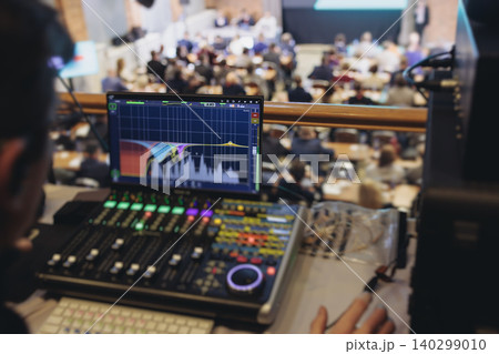 Lighting technician operator working on mixing console, workplace during live event, stage concert show broadcast, light mixer controller panel, sound technician with professional equipment at venue Lighting technician operator working on mixing console, workplace during live event, stage concert show broadcast, light mixer controller panel, sound technician with professional equipment at venue 140299010