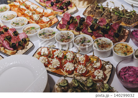 Traditional Russian cuisine dishes on a New Year table, dressed herring salad, kholodets brawn, russian snacks, olivier salad and homemade pickles on catering table banquet, party event celebration Traditional Russian cuisine dishes on a New Year table, dressed herring salad, kholodets brawn, russian snacks, olivier salad and homemade pickles on catering table banquet, party event celebration 140299032