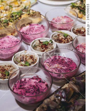 Traditional Russian cuisine dishes on a New Year table, dressed herring salad, kholodets brawn, russian snacks, olivier salad and homemade pickles on catering table banquet, party event celebration Traditional Russian cuisine dishes on a New Year table, dressed herring salad, kholodets brawn, russian snacks, olivier salad and homemade pickles on catering table banquet, party event celebration 140299033