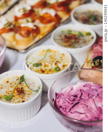 Traditional Russian cuisine dishes on a New Year table, dressed herring salad, kholodets brawn, russian snacks, olivier salad and homemade pickles on catering table banquet, party event celebration Traditional Russian cuisine dishes on a New Year table, dressed herring salad, kholodets brawn, russian snacks, olivier salad and homemade pickles on catering table banquet, party event celebration 140299041