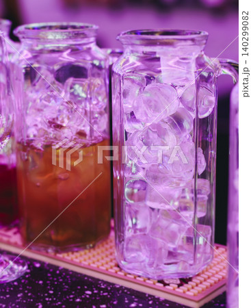Barman mixing and pouring drinks and beverages, beautiful row line of different coloured lemonades in a jar, liquor alcohol cocktails on a party in bar, catering banquet on event, mocktails in a jug Barman mixing and pouring drinks and beverages, beautiful row line of different coloured lemonades in a jar, liquor alcohol cocktails on a party in bar, catering banquet on event, mocktails in a jug 140299082
