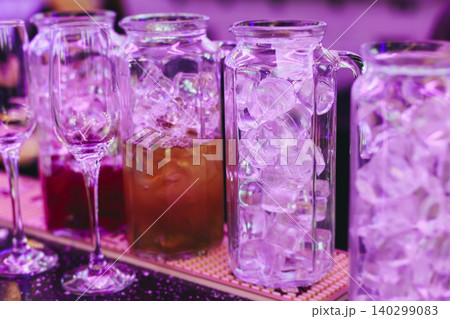 Barman mixing and pouring drinks and beverages, beautiful row line of different coloured lemonades in a jar, liquor alcohol cocktails on a party in bar, catering banquet on event, mocktails in a jug 140299083