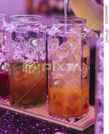 Barman mixing and pouring drinks and beverages, beautiful row line of different coloured lemonades in a jar, liquor alcohol cocktails on a party in bar, catering banquet on event, mocktails in a jug 140299087