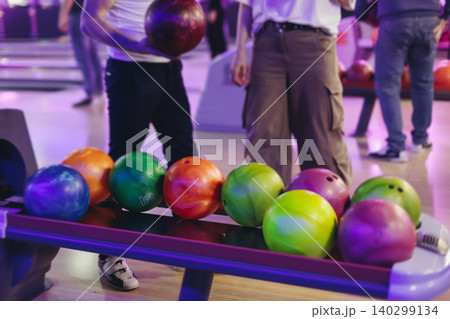 Bowling club play, group team of friends and colleagues playing, throwing a ball on the bowling alley lane, ball and pins, corporate party event in a mall amusement game center, tournament competition Bowling club play, group team of friends and colleagues playing, throwing a ball on the bowling alley lane, ball and pins, corporate party event in a mall amusement game center, tournament competition 140299134