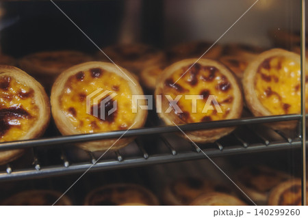 Pasteis and Pastel de nata, traditional Portuguese egg custard tart pasty cakes, dessert Pasteis de nata with different pastry in the cafe, bakery display window, Pastel de belem, Lisbon, Portugal Pasteis and Pastel de nata, traditional Portuguese egg custard tart pasty cakes, dessert Pasteis de nata with different pastry in the cafe, bakery display window, Pastel de belem, Lisbon, Portugal 140299260