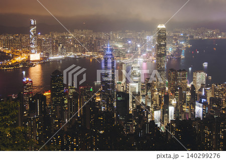 Hong Kong night evening view, China, seen from Victoria Peak observation deck, Lugard road lookout, with Hong Kong downtown skyscrapers and Kowloon island, illuminated city and Victoria Bay at night Hong Kong night evening view, China, seen from Victoria Peak observation deck, Lugard road lookout, with Hong Kong downtown skyscrapers and Kowloon island, illuminated city and Victoria Bay at night 140299276