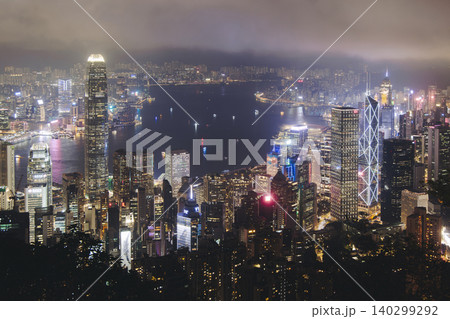 Hong Kong night evening view, China, seen from Victoria Peak observation deck, Lugard road lookout, with Hong Kong downtown skyscrapers and Kowloon island, illuminated city and Victoria Bay at night Hong Kong night evening view, China, seen from Victoria Peak observation deck, Lugard road lookout, with Hong Kong downtown skyscrapers and Kowloon island, illuminated city and Victoria Bay at night 140299292