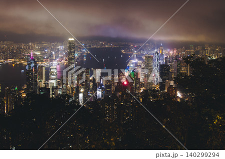 Hong Kong night evening view, China, seen from Victoria Peak observation deck, Lugard road lookout, with Hong Kong downtown skyscrapers and Kowloon island, illuminated city and Victoria Bay at night Hong Kong night evening view, China, seen from Victoria Peak observation deck, Lugard road lookout, with Hong Kong downtown skyscrapers and Kowloon island, illuminated city and Victoria Bay at night 140299294
