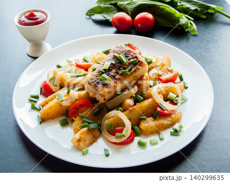 Cooking and healthy eating concept. Plate with baked potatoes, piece of fish, fish and chips meal. 140299635