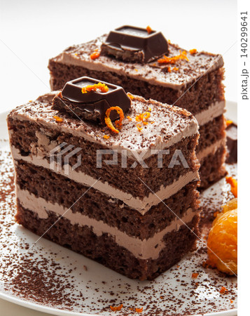 Traditional chocolate cocoa butter condensed milk cream cake with candies, oranges served on plate. Traditional chocolate cocoa butter condensed milk cream cake with candies, oranges served on plate. 140299641