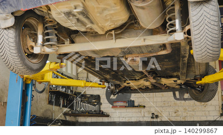Car chassis lifted on a hoist for inspection in a Moscow auto repair shop Car chassis lifted on a hoist for inspection in a Moscow auto repair shop 140299867