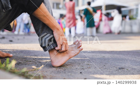 Person's bare foot on the ground, participating in a traditional Hindu festival 140299938