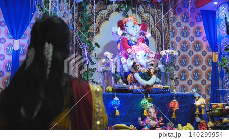 Devotee celebrating Ganesha Chaturthi festival in India, worshipping Lord Ganesha idol Devotee celebrating Ganesha Chaturthi festival in India, worshipping Lord Ganesha idol 140299954