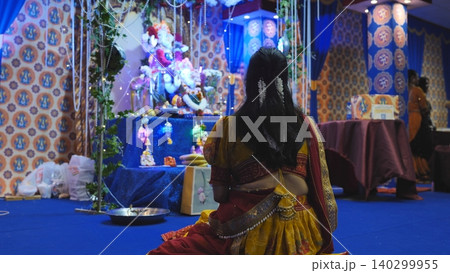 Woman worshiping Lord Ganesha during Ganesh Chaturthi festival in a temple 140299955