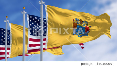 New Jersey state flags waving with the american flag on a clear day New Jersey state flags waving with the american flag on a clear day 140300051