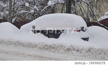 Car covered in deep snow on a street during a heavy winter blizzard and snowfall Car covered in deep snow on a street during a heavy winter blizzard and snowfall 140300278