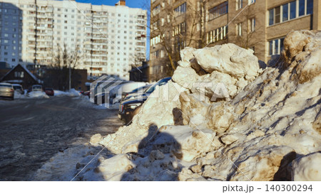 Dirty snow pile blocking urban city street and parking lot in harsh winter weather Dirty snow pile blocking urban city street and parking lot in harsh winter weather 140300294