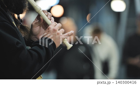 Busker playing recorder, hands pressing keys creating music outdoors, street performance Busker playing recorder, hands pressing keys creating music outdoors, street performance 140300416